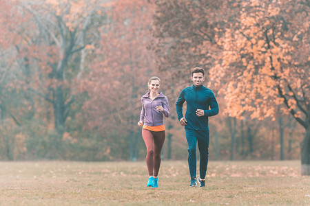 跑步风景摄影照片_情侣在美妙的秋季风景中跑步以提高健身水平