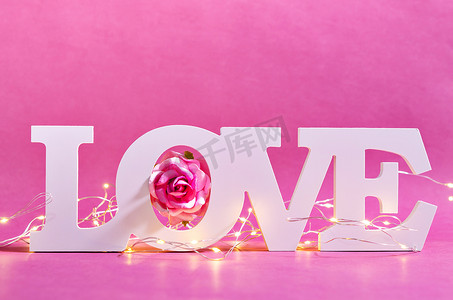 白色爱文本木材和 LED 灯与粉红玫瑰木制背景。