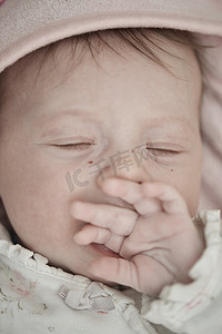 床上睡觉的婴儿摄影照片_刚出生的婴儿在家里的床上睡觉