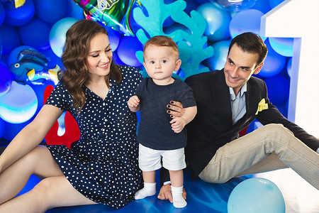 假期中，父亲、母亲和儿子以海洋风格的蓝色装饰为背景
