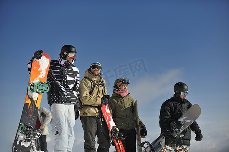单板滑雪者团体放松并享受阳光