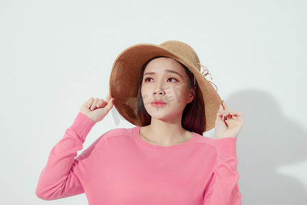 亚洲女性戴着时尚草草沙滩帽进行皮肤护理防晒。
