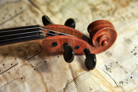 交响乐团背景摄影照片_在笔记背景的老小提琴