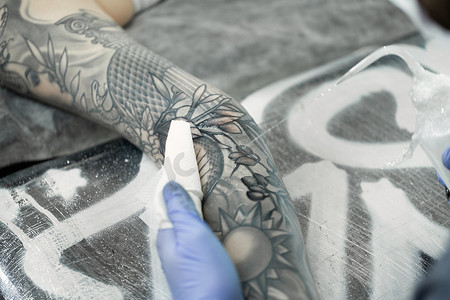 纹身师在一个年轻女孩的手上纹身。