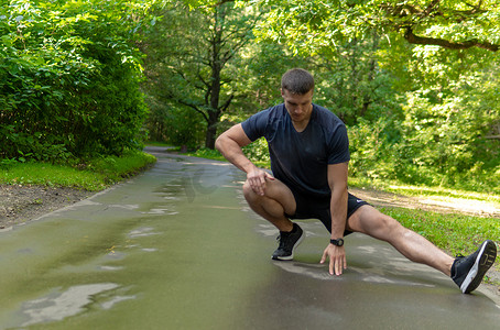 一位年轻持久的运动运动员正在户外森林中做伸展运动，在森林周围，橡树。跑步者自然，健身慢跑运动员慢跑，树林人。