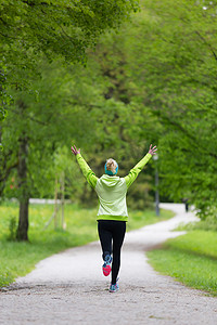 跑步运动的人摄影照片_城市公园里运动的年轻女跑步者。