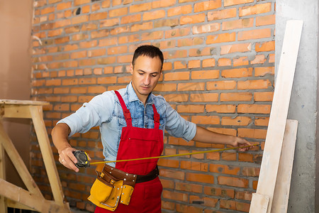维修工工摄影照片_正在装修的建筑中的年轻男性工人或建筑商