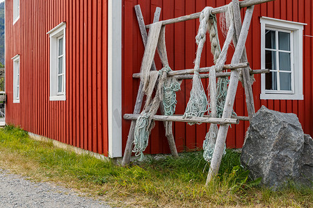 罗弗敦群岛，挂在栅栏或门廊上的渔网，经典的挪威风景，红色的房子，精心挑选的渔网