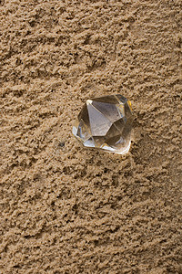 价格透明摄影照片_沙子背景上的透明钻石