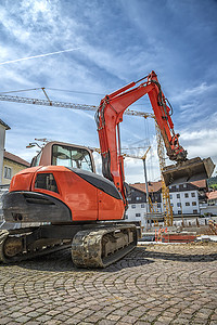 一台大型红色挖掘机在建筑工地工作。