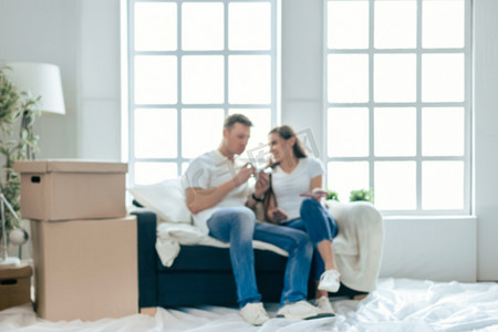 一对年轻夫妇躺在空荡荡的新公寓地板上的背景图片。