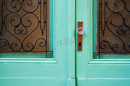 旧地中海风格复古门，带把手、锁孔和玻璃部件，配有锻造花纹格子
