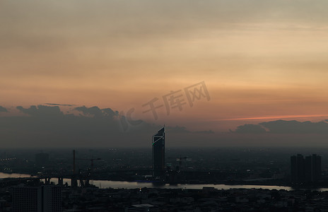 华丽的日出或日落全景，曼谷市的鸟瞰图，俯瞰摩天大楼和横跨湄南河的桥梁，闪烁着明亮的灯光。