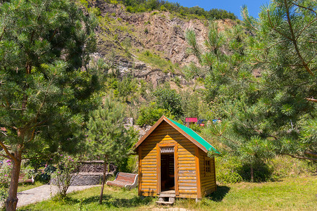 高落基山背景上一座带绿色屋顶的小木屋
