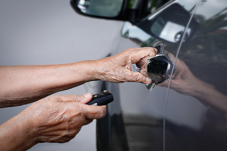 老妇人用钥匙汽车报警系统用手打开汽车