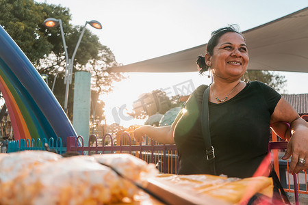 流动摊贩摄影照片_尼加拉瓜马那瓜一个公园里的流动水果摊贩在日落时微笑。