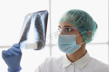 合格的女医生检查患者肺部的 X 射线扫描