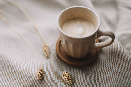 一杯咖啡加牛奶在米色纺织品上。