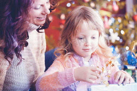 一家人礼物摄影照片_圣诞节那天，一家人在树下打开礼物