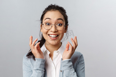 高兴、惊讶的戴眼镜的亚洲女性的特写肖像，为人感到高兴，听到很棒的消息，意识到发生了好事，她赢了或升职了，高兴地笑着