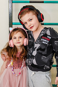 小弟弟和妹妹在家里戴着耳机。