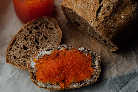 将红鱼子酱放在面包和黄油上，鱼子酱三明治的特写。