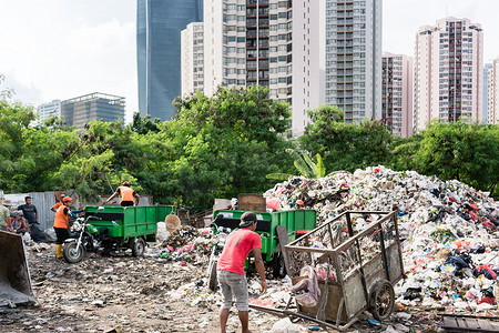 人们在垃圾填埋场处理废料和垃圾
