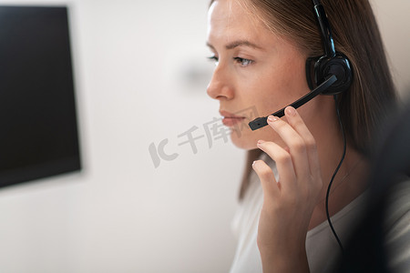 呼叫中心戴着耳机的热线女接线员。戴着耳机在呼叫中心工作的女商人。