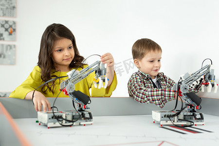 男孩和女孩玩手工机器人。 