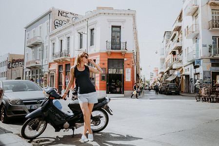 美丽的女孩沿着希腊首都雅典一个古老的欧洲小镇的街道行走。