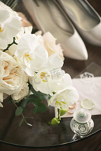 优雅的玫瑰和兰花花束、新娘特写的鞋子和配饰
