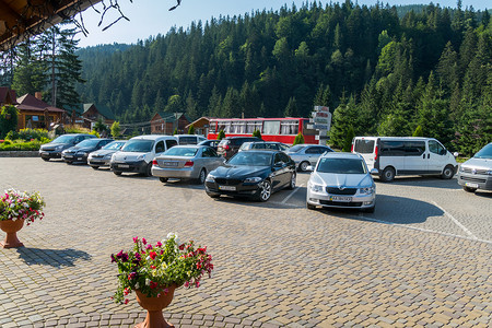 酒店附近的停车场停满了知名品牌的汽车，后面是旅游巴士。