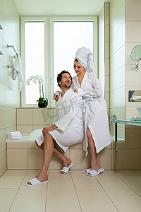 酒店浴室摄影照片_酒店浴室里穿着浴袍的年轻夫妇