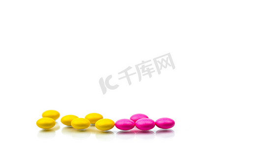 一堆粉色和黄色圆形糖衣片丸，在白色背景上隔离，并带有复制空间。