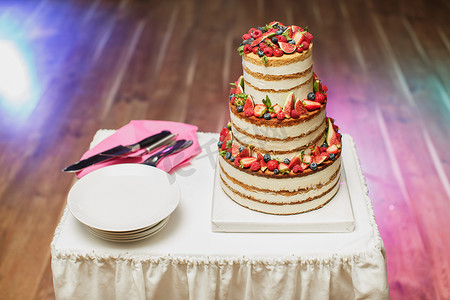 生日宴摄影照片_婚礼蛋糕与浆果在宴会上。