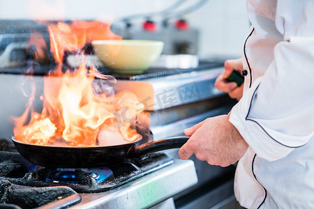 厨房做菜摄影照片_厨师在锅里做菜的火焰