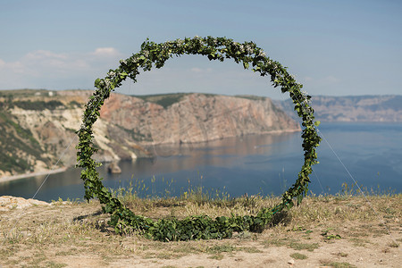 海洋背景悬崖上的环形婚礼拱门。