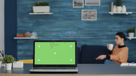 家中办公桌上配有绿屏模板的现代笔记本电脑