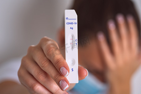 悲伤的妇女进行快速 covid 抗原测试或表达 covid 测试，冠状病毒结果呈阳性。