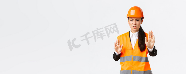 戴着安全帽、穿着反光服、失望而愤怒的亚洲女工程师说停止、禁止和不同意施工经理的意见，表现得足够多，没有手势，白色背景
