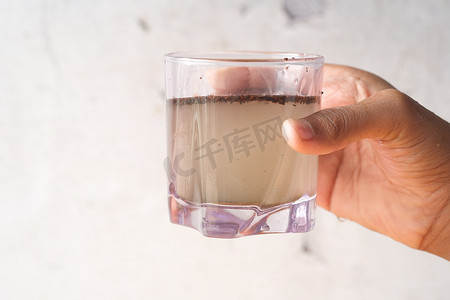 保温水杯水摄影照片_拿着脏杯水和复制空间