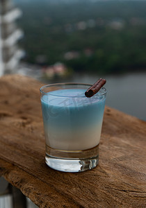 花背景奶茶摄影照片_一杯来自蝴蝶豌豆植物（clitoria）干花的蓝色抹茶拿铁茶或蝴蝶豌豆花奶茶拿铁。