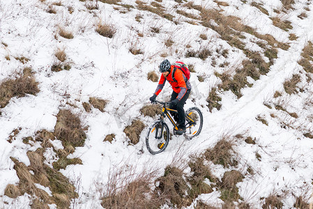 骑自行车的人在雪道上骑红色山地自行车。
