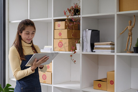 年轻的亚洲女性在家检查发货订单，企业主女性创办在线业务，中小企业，交付项目，具有在线业务或中小企业概念的女性
