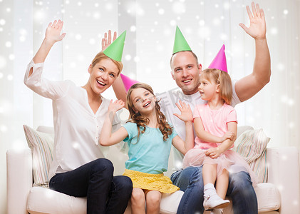 幸福的家庭，有两个孩子在家里戴着派对帽