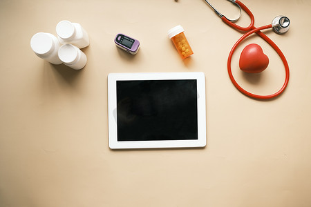桌上的数字平板电脑、听诊器和药丸容器