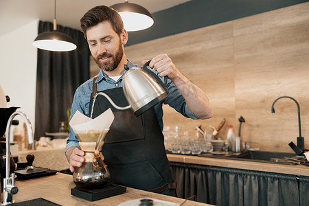 咖啡师使用手动滴灌咖啡机倒水煮咖啡