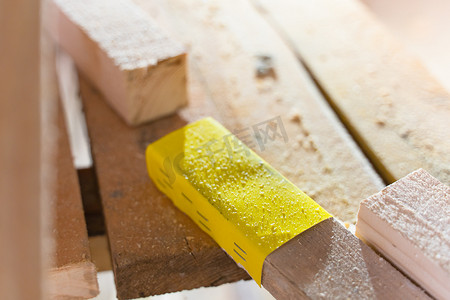 黄色砂纸用钢钉特写钉在木梁上