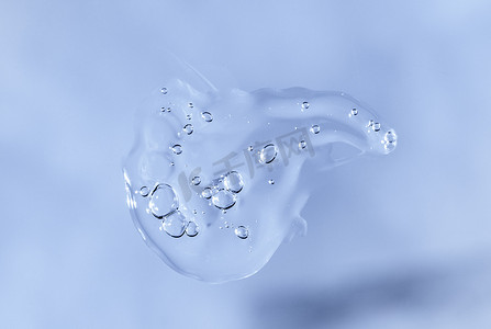 蓝色单色背景上的液体透明质酸滴。