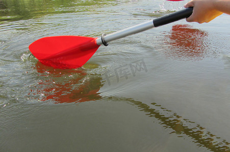 红色划船摄影照片_红色桨用于白水漂流和皮划艇。